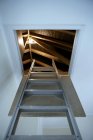 Escalera que conduce al desván iluminado - foto de stock