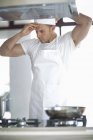 Männlicher Koch passt Mütze in Großküche an — Stockfoto