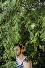 Junger Mann mit Kopfhörern steht in Waldpark — Stockfoto