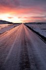 Route gelée dans un paysage enneigé au coucher du soleil, iceland — Photo de stock