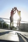 Runners jumping doing high-five, Munich, Allemagne — Photo de stock