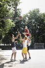 Grupo de amigos divirtiéndose jugando baloncesto - foto de stock