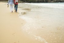 Recorte de pareja adulta paseando por la playa, Camaret-sur-mer, Bretaña, Francia - foto de stock