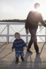 Enfant garçon et père marchant au bord du lac — Photo de stock