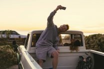 Mann macht Smartphone-Selfie mit Freundin in Pickup-Truck am Strand von Newport, Kalifornien, USA — Stockfoto