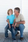 Smiling father and son on deck — Stock Photo