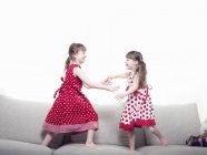 Девушки играют вместе на диване — стоковое фото