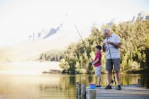 Garçon pêche avec grand-père dans le lac — Photo de stock