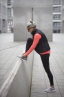 Madura mujer formación en la ciudad, atar cordones entrenador - foto de stock