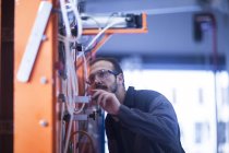 Junger erwachsener männlicher Ingenieur inspiziert schwere Maschinen — Stockfoto