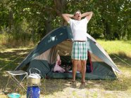 Man stretching outside tent — Stock Photo