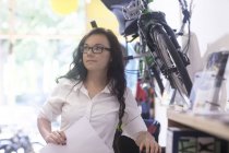 Woman in bicycle shop holding paperwork — Stock Photo