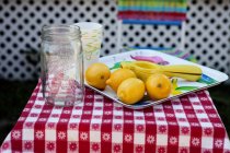 Limones frescos y vasos de papel - foto de stock