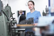 Portrait of female engineer holding a tray of drillbits — Stock Photo