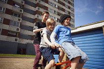Мальчик дарит друзьям-мужчинам поездку на велосипеде в Лондоне, Великобритания — стоковое фото