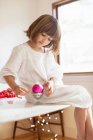 Girl on table playing with Christmas decorations — Stock Photo