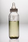Бутылка для младенца с грязной водой на столе, концепция здоровья — стоковое фото