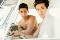 Young men inside car posing for camera — Stock Photo