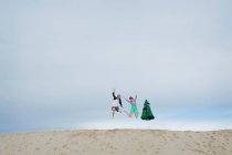 Young couple leaping on beach — Stock Photo