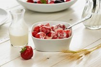 Bowl of strawberries and glass of milk — Stock Photo