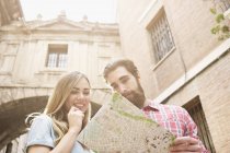 Молодая туристическая пара смотрит на карту за пределами Валенсии, Валенсия, Испания — стоковое фото