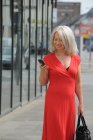 Ältere Frau nutzt Handy im Freien — Stockfoto