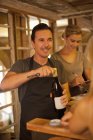 Garrafa de vinho de abertura sommelier masculino na loja de vinhos — Fotografia de Stock