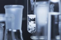 Plan rapproché de la réaction chimique du carbonate de sodium dans une fiole en verre — Photo de stock