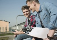 Due giovani uomini in skatepark utilizzando smartphone — Foto stock
