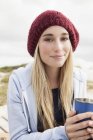 Young woman holding cup of coffee on cold day — Stock Photo