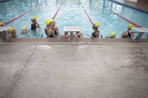 Large group of schoolgirls taking a break in swimming pool — Stock Photo