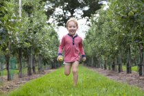Хлопчик біжить яблучним садом — стокове фото