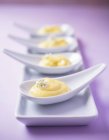 Quattro dessert di crema pasticcera su cucchiai di porcellana — Foto stock