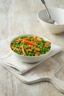Peas and carrots in bowl — Stock Photo
