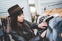 Young woman browsing clothes at market — Stock Photo