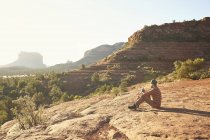 Человек, сидящий и смотрящий на вид, Седона, Аризона, США — стоковое фото