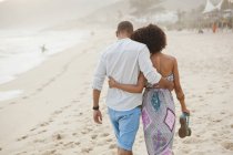 Vista traseira do casal passeando na praia, Rio De Janeiro, Brasil — Fotografia de Stock