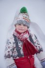 Портрет милого мальчика, лежащего в глубоком снегу — стоковое фото
