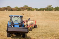 Tractor and thresher in crop field — Stock Photo