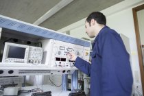 Panel de control de prueba de electricista masculino en taller - foto de stock