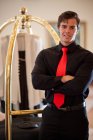 Porter with luggage cart in hotel lobby — Stock Photo