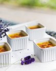 Quatre plats de crème anglaise caramélisée sur la table — Photo de stock