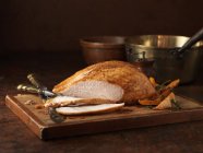 Organic roasted turkey breast on chopping board — Stock Photo