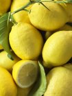 Pile of fresh lemons with leaves, close up shot — Stock Photo