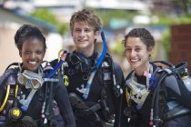 Portrait of three cheerful young adult scuba divers — Stock Photo