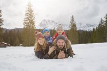 Portrait of parents and sons lying in snow covered landscape, Elmau, Bavaria, Germany — Stock Photo