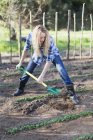 Woman shoveling dirt in garden — Stock Photo