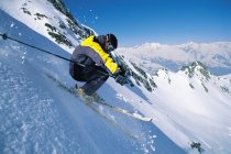 Лыжник спускается с холма — стоковое фото