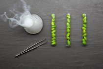 Beans in test tubes with smoking beaker — Stock Photo