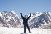 Hiker cheering on snowy mountaintop — Stock Photo